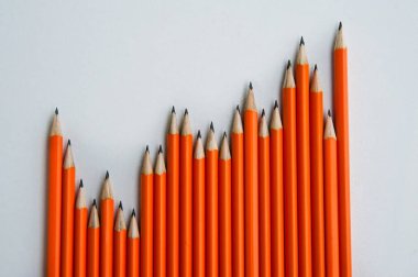 Geri okul kavramı. Bir sürü üst üste bir tablo üzerinde turuncu kalemler.