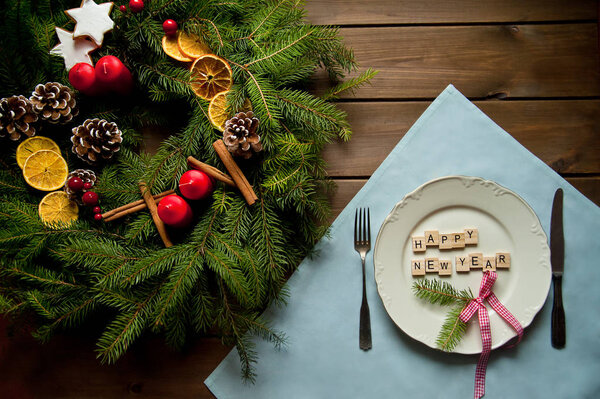 Творческая рождественская композиция с венком и таблицей со словами: С Новым годом. Необычная идея для декора дома отдыха в винтажном стиле. Естественный интерьер на деревянном фоне. Плоский лежал
