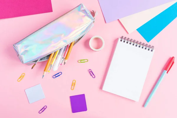 Kalem, kalem, fırça, ataç, kitap ayracı, pembe arka planda çok renkli kağıt ve diğer kırtasiyeli kalem kutusu. Metnin yeri, minimalizm. Okul, ofis, eğitim kavramı.