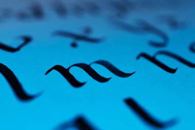 İngiliz alfabesinin harfleri mürekkep ve kalemle yazılmıştır. Klasik el yazması konsepti. Mektup makro fotoğrafı. Kaligrafi eğitimi. Mavi ışık.