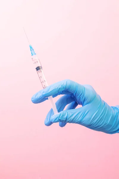 ピンクの背景に白い錠剤と青い医療用手袋で手 健康の概念 ミニマリズム テキストの場所 垂直写真 — ストック写真