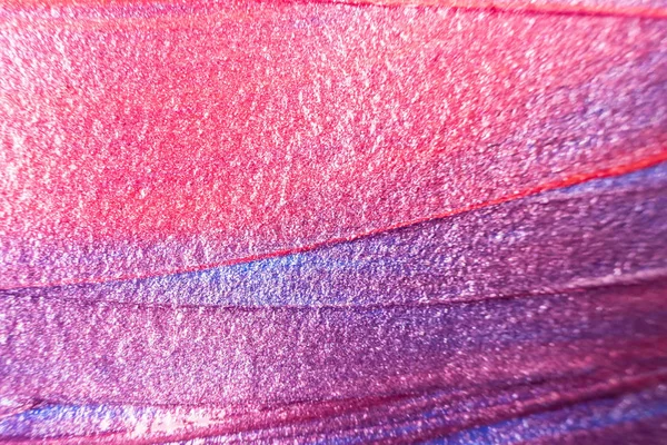 Macro photo. Paint of purple, red and pink shades close up. Abstract bright image of acrylic paint. The concept of drawing, art therapy. Mother of pearl background.
