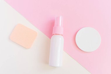 Kozmetik süngerler ve jöleli ve pembe arka planlı bir şişe. Yüz ve vücut bakımı kavramı, kozmetoloji. Minimalizm, üst görüş. Metin için boşluk