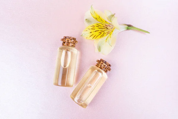 芳香疗法的概念 瓶中的花精油和一朵黄色的花在粉红的粉底上 舒适的平铺着明亮的色彩 复制空间 简约主义 顶视图 — 图库照片