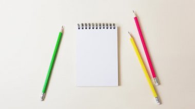 Kırtasiye malzemeleri yavaş yavaş arka planda belirir: defter, kalem, ataç, ataç, ataç, düğme. Öğrenme, okul, iş, yaratıcılık, hobi. 4k hareketini durdur.