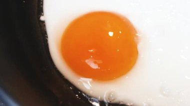 Fried egg close-up: whole yolk in focus. The concept of fried food, breakfast.