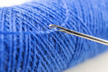 İğneli mavi iplik. Ayrıntılı makro fotoğraf. Dikiş dikme, atölye, hobiler, ödevler.