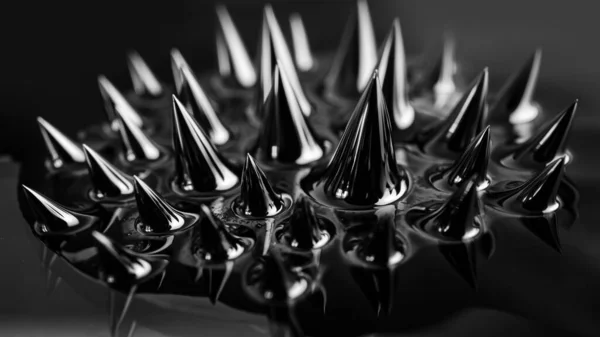 Ferrofluid, magnetic fluid close-up. Abstract minimalistic black trendy background. Banner 16:9. Impressive, stylish iridescent black spikes.