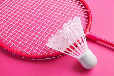 Badminton raketi ve parlak pembe bir arka planda mekik penisi. Amatör sporların envanter konsepti. Minimalizm.