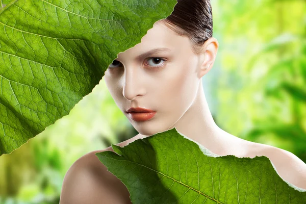 Portret uroda Kobieta Twarz. Piękny model dziewczyna z doskonałą świeży czystą skórę. Dziewczyna z zielonymi liśćmi. Naturalna czystość — Zdjęcie stockowe