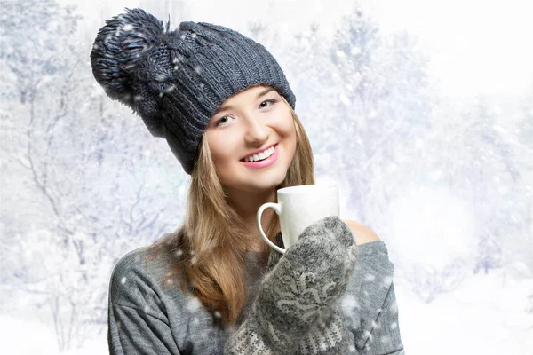 Zimowe Portret młodej kobiety uśmiechający się w Czapka. Zimowa Czapka i rękawiczki z jednym palcem. wesoła dziewczyna śnieżny tło — Zdjęcie stockowe