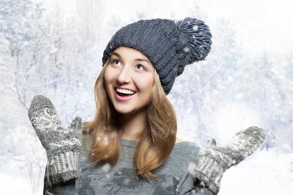 Kış örme şapka içinde genç gülümseyen kadın portresi. Kış şapka ve örme eldivenler. neşeli kız karlı arka plan — Stok fotoğraf