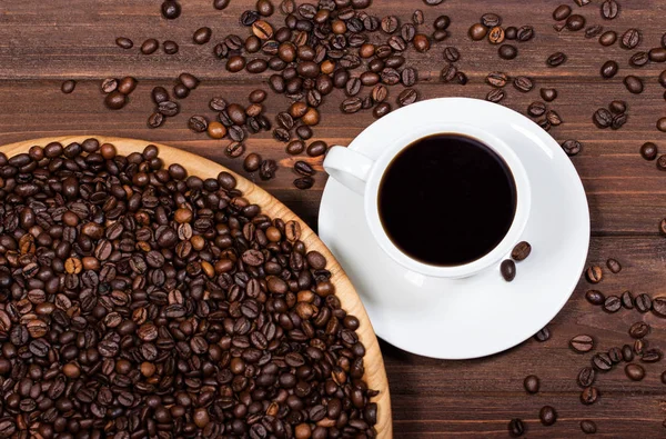 Cup of coffee and coffee beans on a wooden table. Horizontal top view — Stock Photo, Image