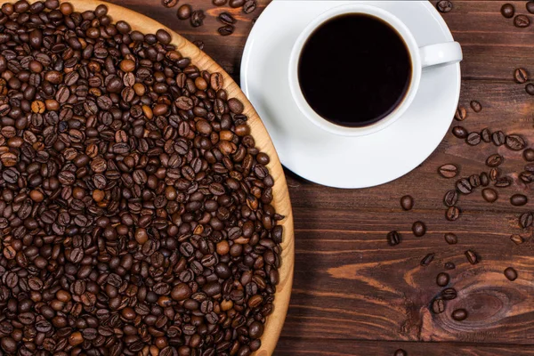 Fincan kahve ve kahve çekirdekleri ahşap bir masa üzerinde. Yatay Üstten Görünüm — Stok fotoğraf