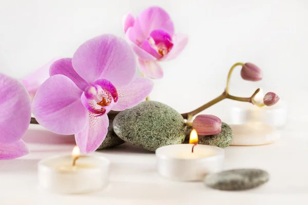 Spa ainda vida com velas aromáticas, flor de orquídea e pedras — Fotografia de Stock