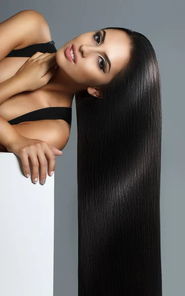 Creative portrait of a beautiful brunette model. The girl is posing in the studio. Long perfect hair streaming down — Stock Photo, Image