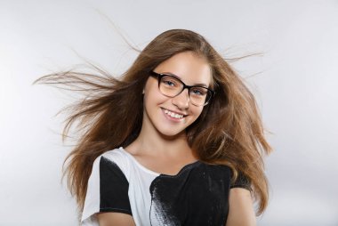 Gözlük ile akıllı güzel kız. Uçan rüzgar saç. Güzel gülümseme