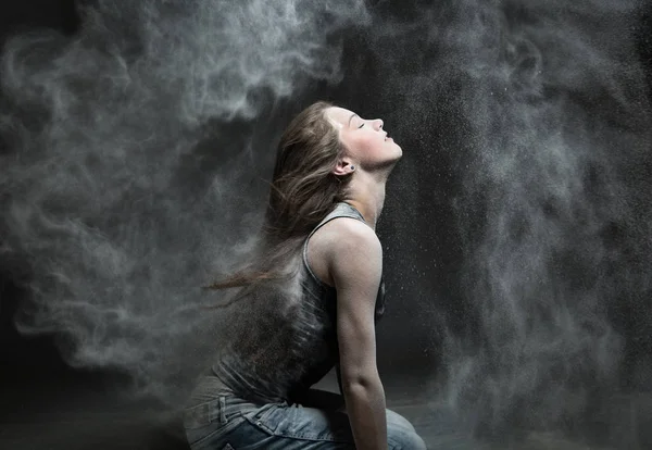 Fille dans le nuage de poussière. Jeune fille à l’arrière-plan de la farine, gris — Photo