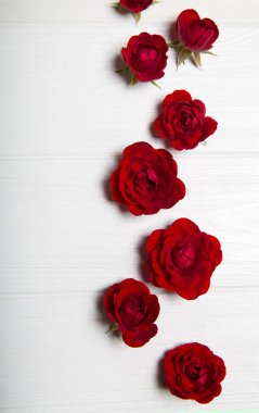 Kırmızı gül Beyaz ahşap bir masa üzerinde. Yukarıdan görüntüleyin. Çiçek deseni.