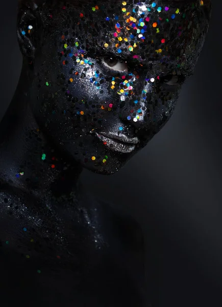 Kreatives Frauenporträt. Gesicht in schwarzer Farbe mit großen Pailletten — Stockfoto