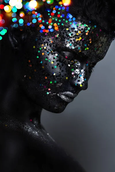 Kreatives Frauenporträt. Gesicht in schwarzer Farbe mit großen Pailletten — Stockfoto