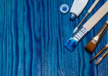 güzel ahşap arka plan parlak mavi boya ile boyanmış. bir tüp boya ve fırça açın