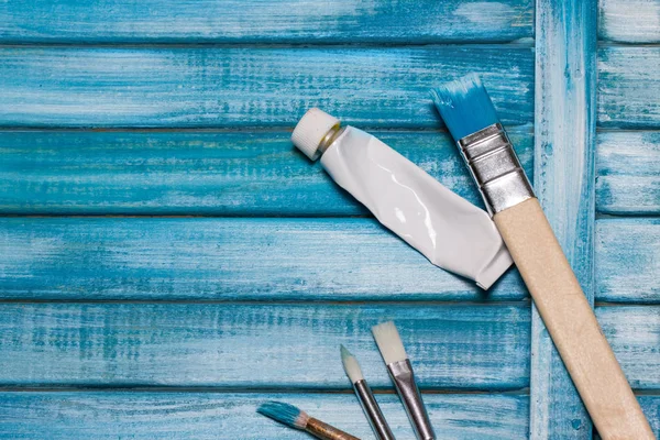 新たに塗られた板ターコイズ ブルー塗料および塗料のブラシ — ストック写真