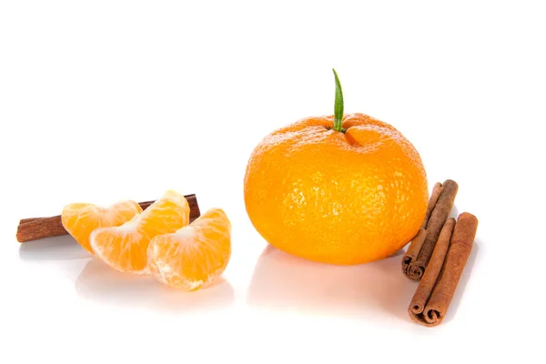 Mandarin with a leaf. cleaned next to slices and cinnamon sticks. — Stock Photo, Image