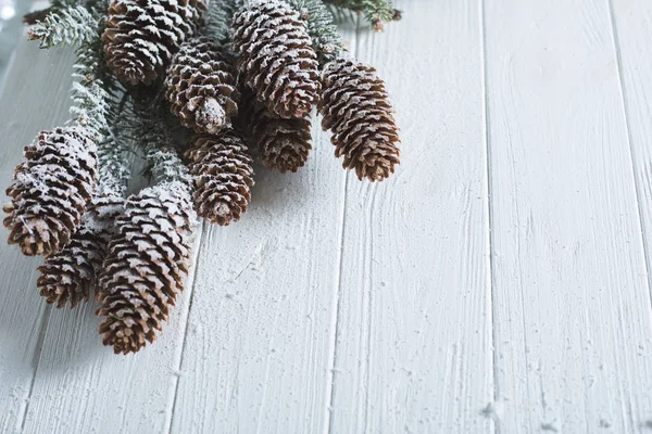 Christmas background with fir branches and cones. White wooden boards. Snow-covered winter background — Stock Photo, Image