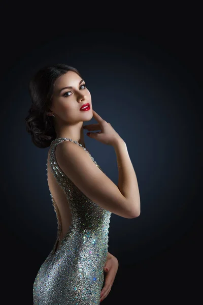 Retrato de moda de belleza de un hermoso modelo en un vestido de noche bordado con piedras. Chica sobre un fondo negro. Piedras brillantes y cristales . — Foto de Stock