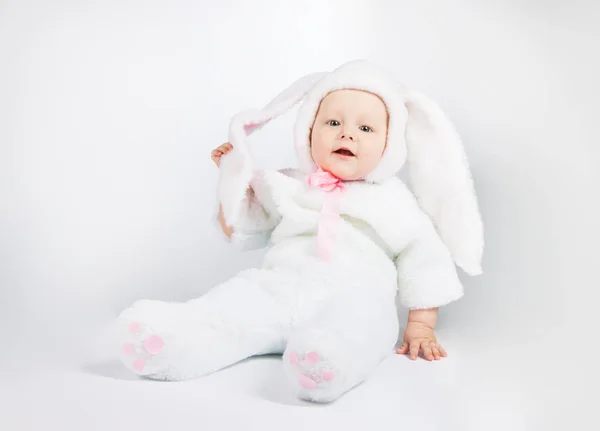 Kis aranyos baba egy fehér nyúlruhát. — Stock Fotó