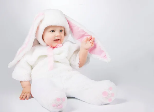 Kleine schattige baby in een witte Bunny kostuum. Stockfoto