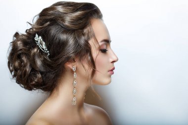 Güzel kadın kafa. Profil. Portre portre. Mükemmel cilt, güzel saç ve makyaj. Büyük ve parlak süslemeleri.