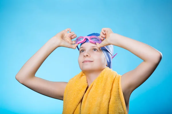 Schwimmerin mit Badekappe und Brille. das Mädchen hält eine Taucherbrille. sie schaut auf. — Stockfoto