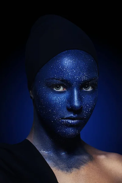 Porträt eines jungen schönen Mädchens. Gesicht mit blauer Farbe und Glitzern bemalt. — Stockfoto