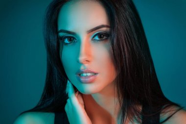 Güzel kadın modeli yakın çekim yaratıcı stüdyo portre. Mavi ışıklar. Kameraya bakarak