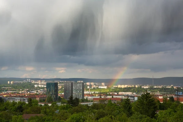 Spectacular rain clouds and rainbow over city