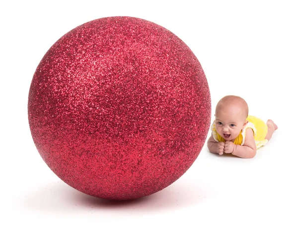 Carino bambino sorridente a un enorme ornamento di Natale su bianco — Foto Stock