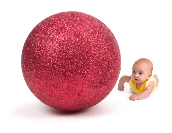 Carino bambino guardando un enorme ornamento di Natale su bianco — Foto Stock