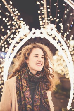 Dışarıdaki kız, arka planda Noel ışıkları.