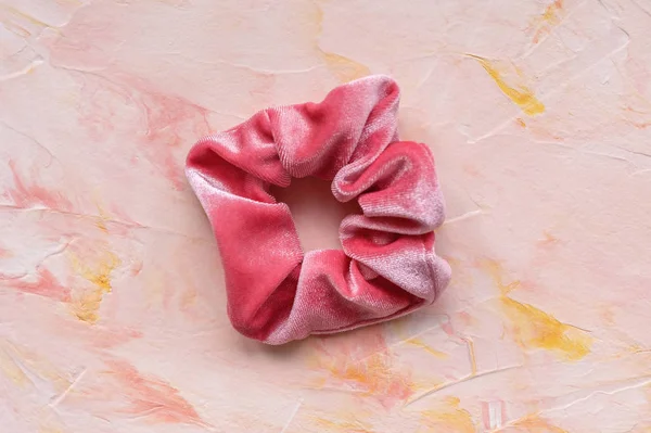 Un scrunchie de terciopelo de moda rosa sobre fondo pastel —  Fotos de Stock