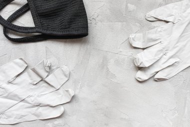 Siyah pamuk maskeli ve tıbbi lastik eldivenli.