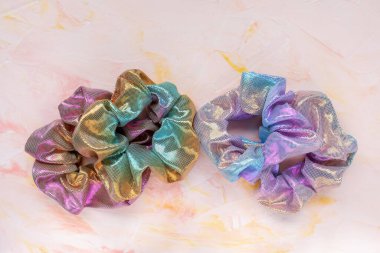 Pembe arka planda dört modadan oluşan holografik tokalar