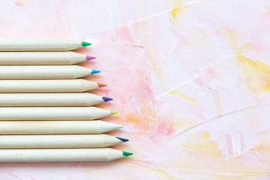 Pembe arka planda çok renkli kalemler