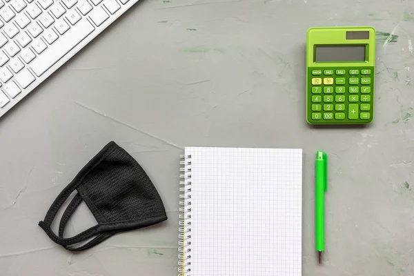 Home office background. Mask and notebook on gray