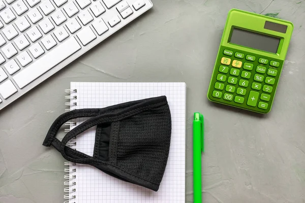 Home office background. Mask and notebook on gray