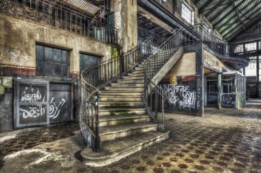 Imposing staircase inside the hall of an abandoned power plant clipart