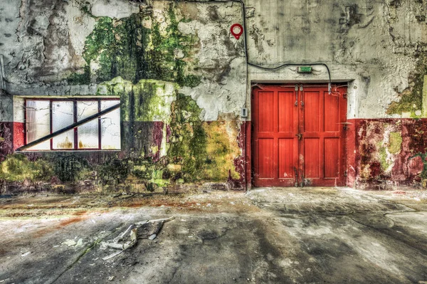 Rote Holztür in einer verfallenen Lagerhalle — Stockfoto