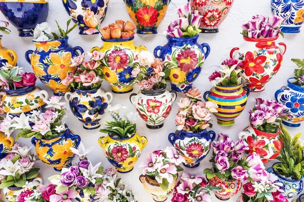 Цветные керамические вазы с цветами на стене магазина в Михасе — стоковое фото