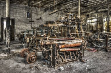 Old weaving looms and spinning machinery at an abandoned factory clipart